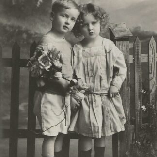 Jongen en meisje staan voor een hek  - fotokaart