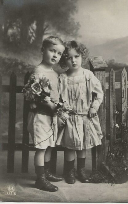 Jongen en meisje staan voor een hek  - fotokaart