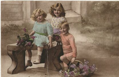 Drie kinderen op bankje met bloemen